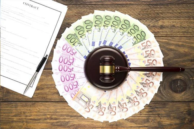 billets d'argent en cercle à côté d'un contrat immobilier